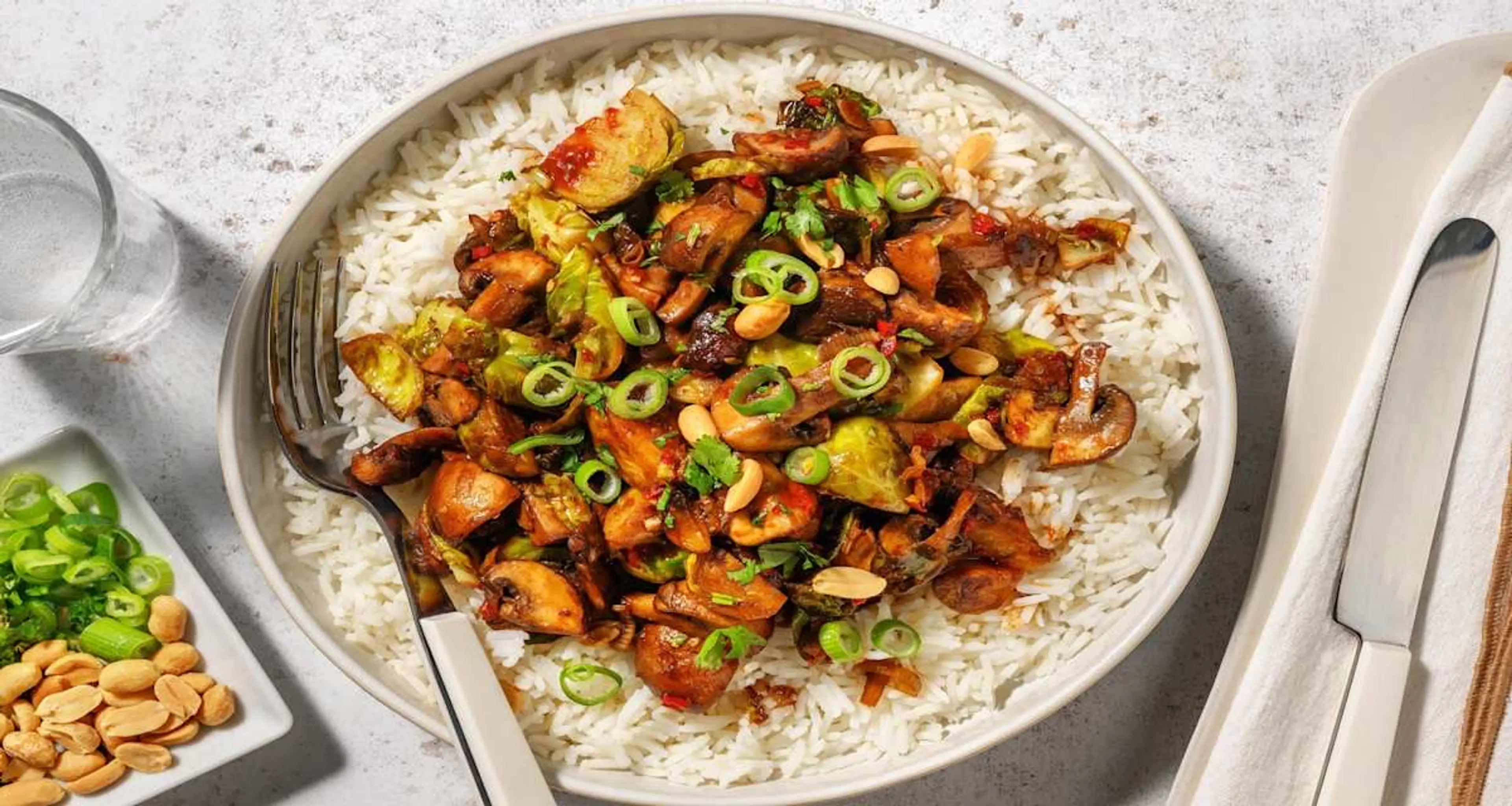 Umami stir-fry met champignons en spruitjes met rijst, pinda