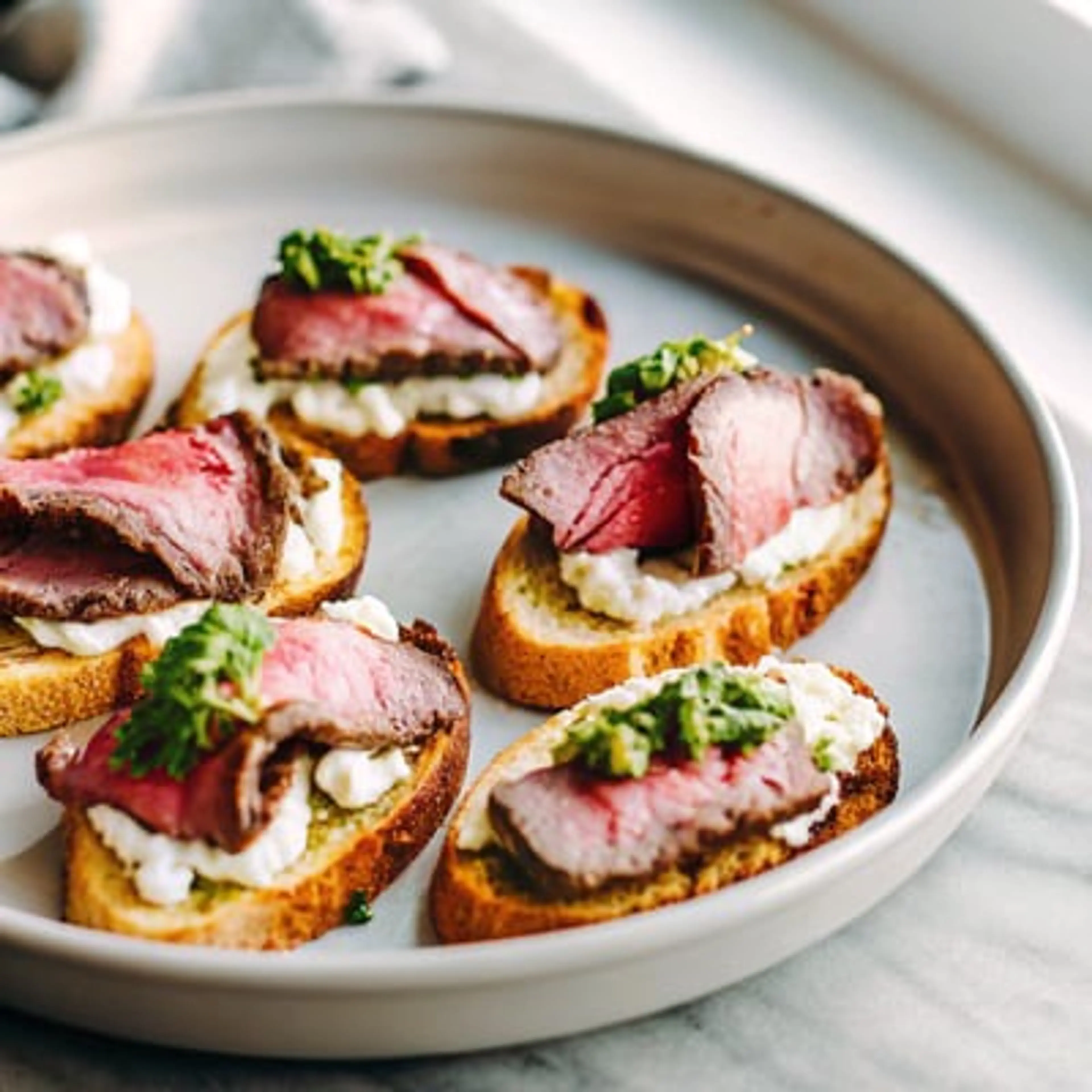 Beef Tenderloin Crostini with Whipped Goat Cheese and Pesto