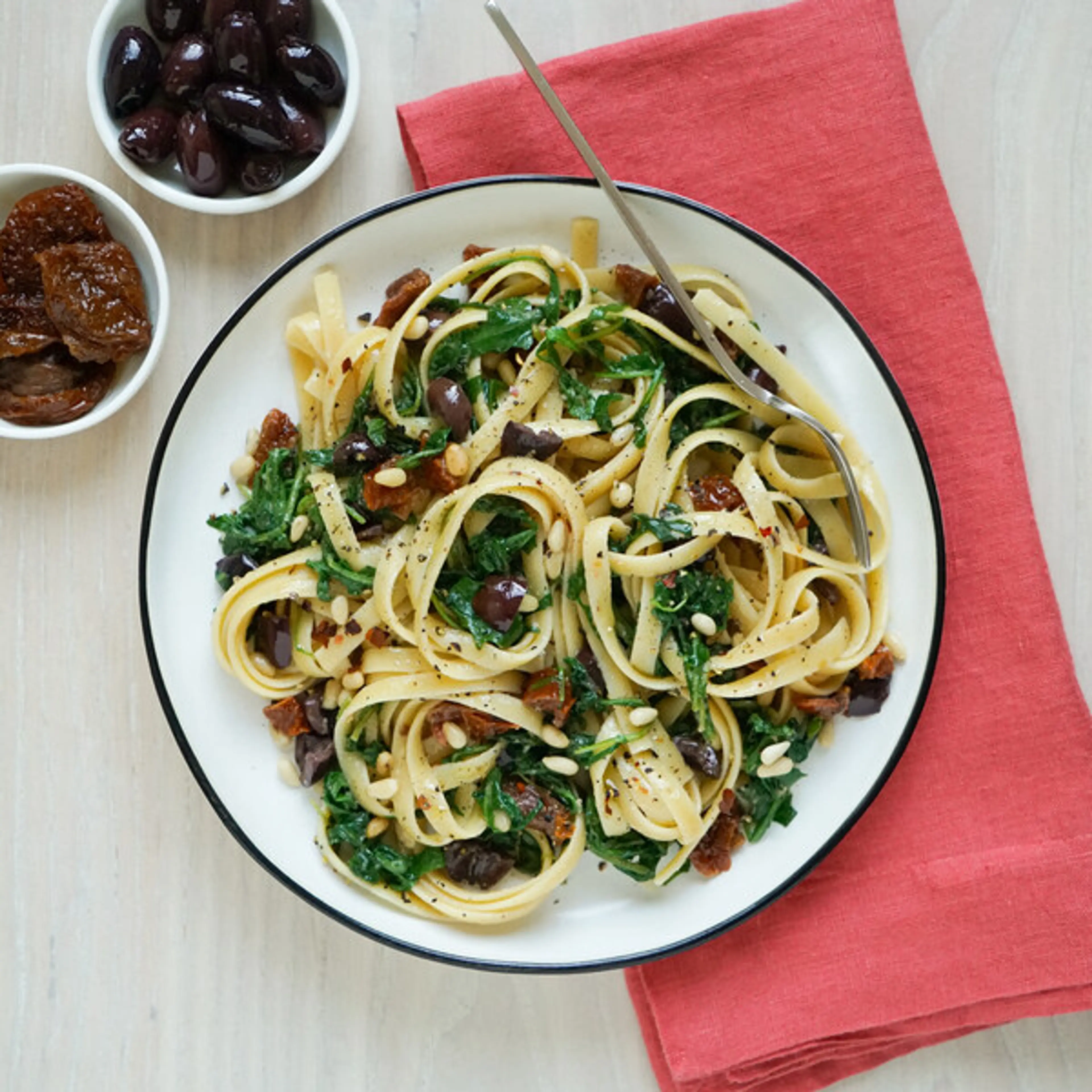 Sun-Dried Tomato Fettuccine with Olives, Pine Nuts, Arugula