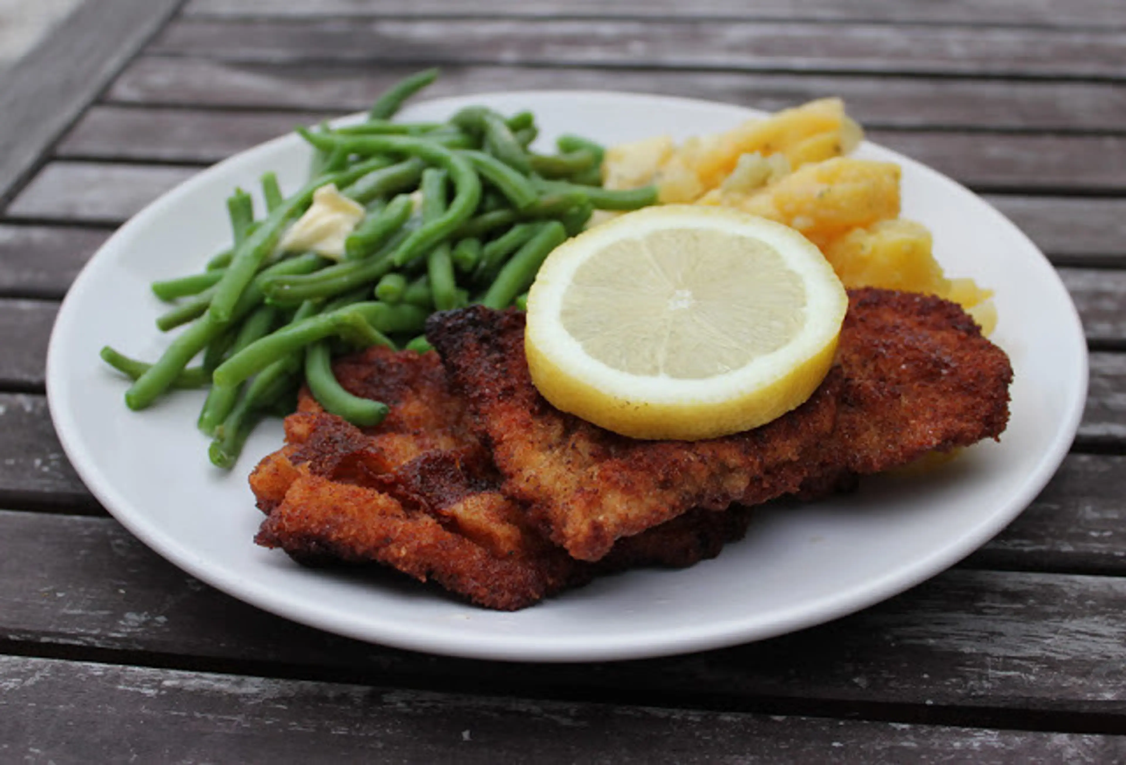 Schnitzel mit Kartoffelspalten und Brechbohnen
